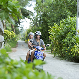 Couple riding a scooter in the paths of the Islands of Tahiti