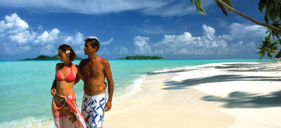 Couple walking on a paradisiac beach in The Islands Of Tahiti